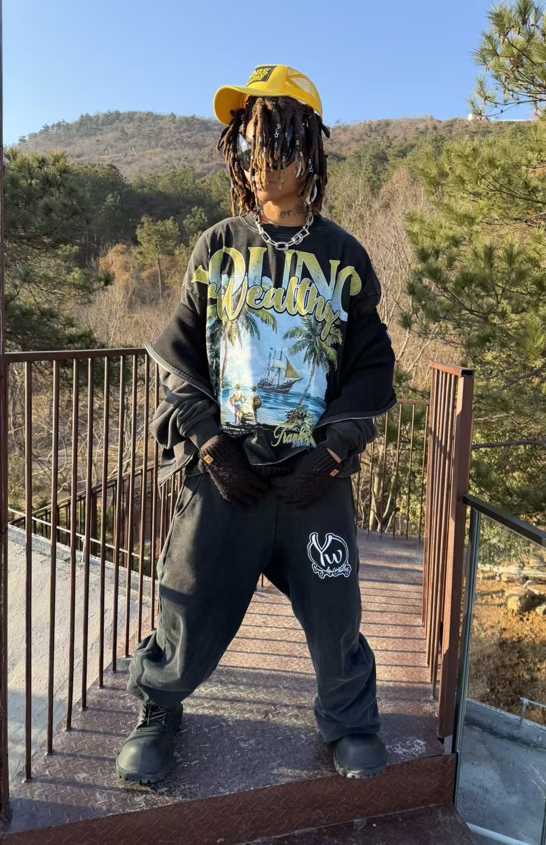 Outdoor campaign look featuring the Young & Wealthy noir hoodie and matching pants